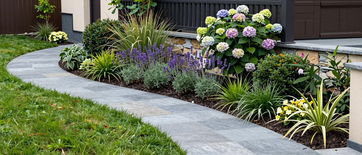 Neu verlegter Gartenweg aus Naturstein mit Kieskante, Lavendel, Straeuchern und Ziergraesern