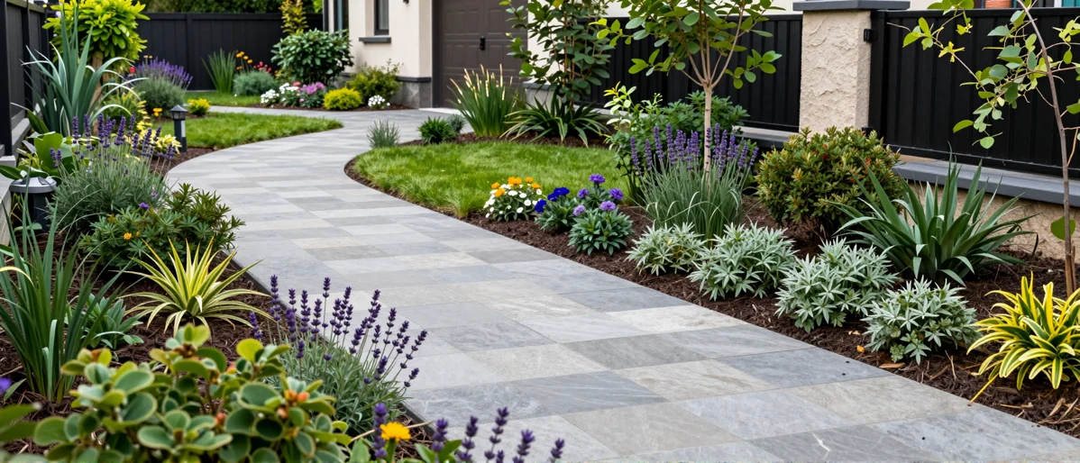 Frisch bepflanztes Gartenbeet neben einer Terrasse mit Lavendel, Hortensien, Straeuchern und Ziergraesern