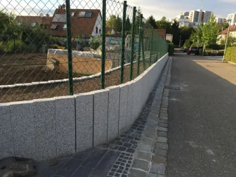 Palisaden und geschwungene Einfassung entlang eines Gartenwegs