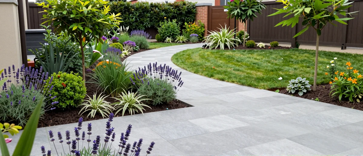Frisch bepflanztes Gartenbeet neben einer Terrasse mit Lavendel, Hortensien, Straeuchern und Ziergraesern